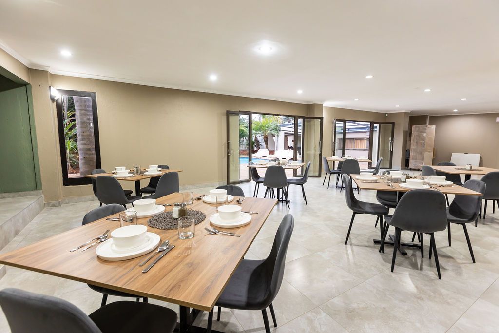 Breakfast room with set tables overlooking the pool