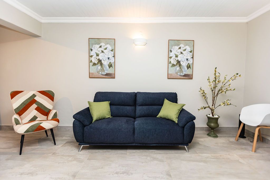 Guest lounge with a navy sofa and patterned armchair